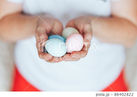 woman's hands holding colored pastel eggs eater woman's hands holding colored pastel eggs eater 86402822