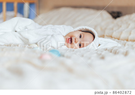 Cute smile happy little baby in white rabbit costume, playing with colorful easter eggs Cute smile happy little baby in white rabbit costume, playing with colorful easter eggs 86402872
