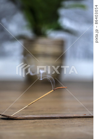 Concept of slow-living and mindfulness. Aromatic saldanwood frankincense smolding stick. Burning candle. Aromatherapy practise. Finding peace and rest. Spiritual ritual at home 86403054