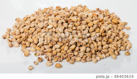 Pile of unshelled pistachios on white Pile of unshelled pistachios on white 86403619
