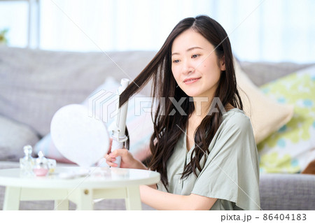 カールヘアアイロンを当てる女性 カールヘアアイロンを当てる女性 86404183