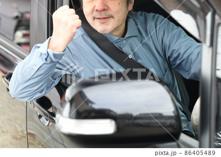 車に乗るガッツポーズをする高齢者（シニア）の白髪男性ドライバー 86405489