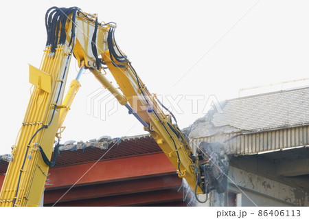 老朽化した公共建造物の解体作業をする重機 86406113