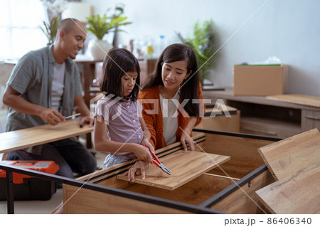 asian family at their new house buying and assembling new furniture. 86406340