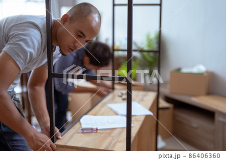 two male woodworker assembling new furniture together 86406360