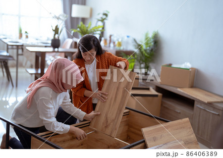 two friend helping each other making new furniture two friend helping each other making new furniture 86406389