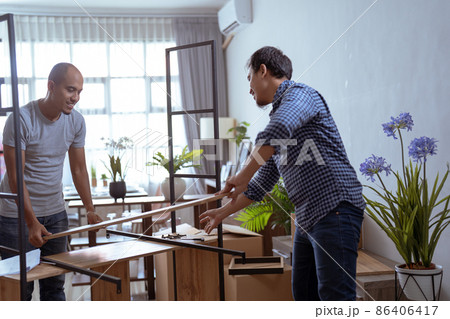 two male woodworker assembling new furniture together two male woodworker assembling new furniture together 86406417