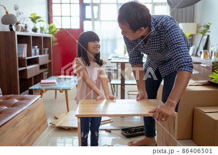 asian father and daughter assembling new furniture at their home 86406501