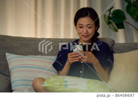 深夜スマホを見る女性 86406697