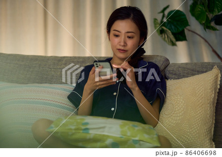 深夜スマホを見る女性 86406698