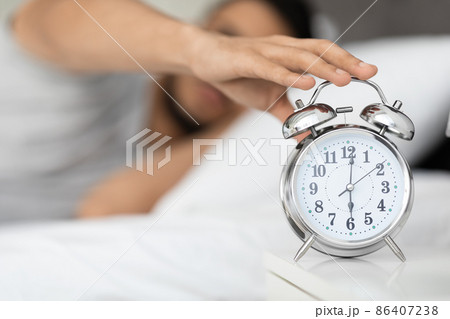 Time To Wake Up. Man Reaching Alarm Clock On Bedside Table, Closeup Time To Wake Up. Man Reaching Alarm Clock On Bedside Table, Closeup 86407238
