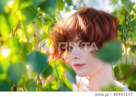 Portrait of a red-haired happy woman in park Portrait of a red-haired happy woman in park 86407247