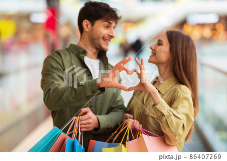 Happy Couple Shopping Making Heart Shape Joining Fingers In Hypermarket 86407269