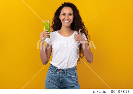 Portrait of Smiling Young Lady Drinking Smoothie Showing Like 86407318