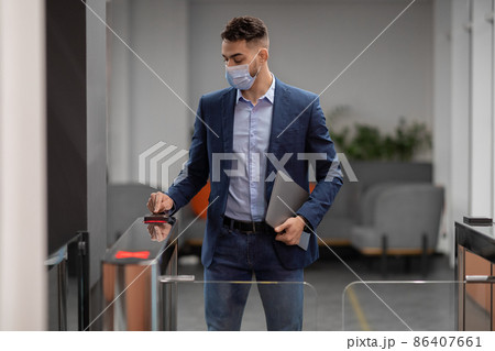 Arab guy in face mask employee entering security code Arab guy in face mask employee entering security code 86407661