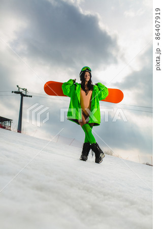 Young beautiful woman posing with a snowboard on a ski slope 86407919