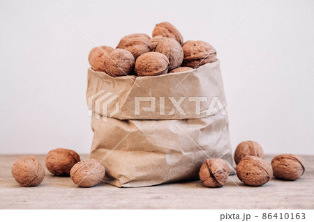 Walnuts in a paper bag on a old rustic table. Walnuts in a paper bag. Copy, empty space for text Walnuts in a paper bag on a old rustic table. Walnuts in a paper bag. Copy, empty space for text 86410163