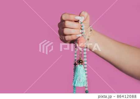Woman lit hand counts mala beads strands of gemstones used for keeping count during mantra 86412088