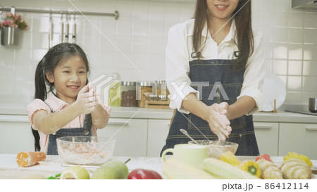 young mother, and daughter little prepare wheat flour to bake bread 86412114