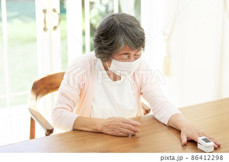 パルスオキシメーターを使うシニア女性 86412298