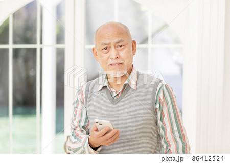 スマートフォンを使うシニア男性 スマートフォンを使うシニア男性 86412524