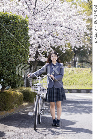 桜の中自転車通学する女子高生 86414063