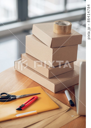 Packages stacked on a round wooden office desk 86414784