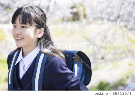 桜並木の中を通学するマスク姿の新中学生　小学校卒業　入学イメージ 86415671