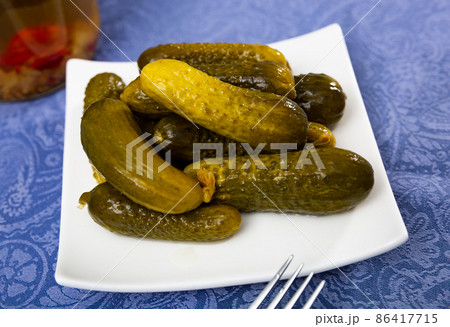 Pickled cucumbers on white plate, homemade preserves Pickled cucumbers on white plate, homemade preserves 86417715
