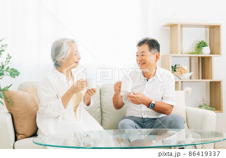 ソファに座る高齢者夫婦（お茶） 86419337