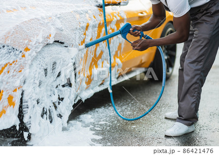 Crop close up of car washing with high pressure foam. Crop close up of car washing with high pressure foam. 86421476