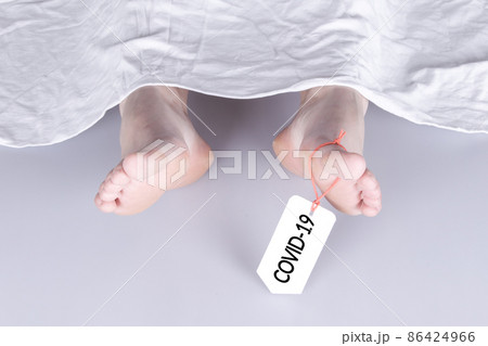 Body with toe tag on white 86424966