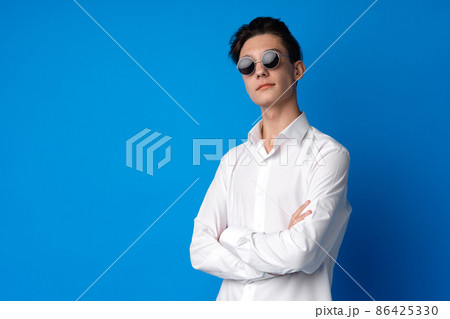 Portrait of a smiling teen boy against blue background 86425330