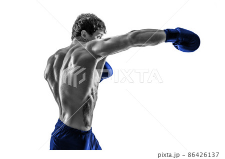 Side view of boxer in blue gloves who practicing swing on white background. Black and white 86426137