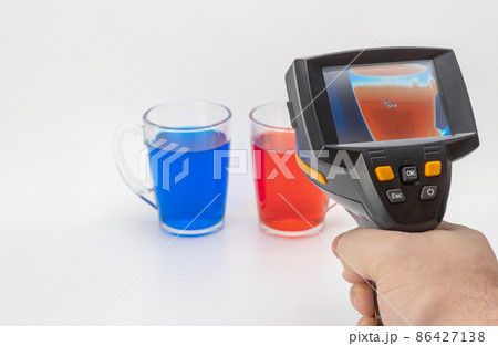 cup with a hot drink is displayed on the thermal imager screen. selective focus. the temperature meter shows the heat level. display shows a hot object. 86427138