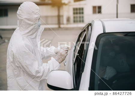 Doctor Hands in protective gloves holding Coronavirus 2019-nCoV Vaccine vial in a protective suit taking a nasal swab from a person to test for possible coronavirus infection. Doctor Hands in protective gloves holding Coronavirus 2019-nCoV Vaccine vial in a protective suit taking a nasal swab from a person to test for possible coronavirus infection. 86427726