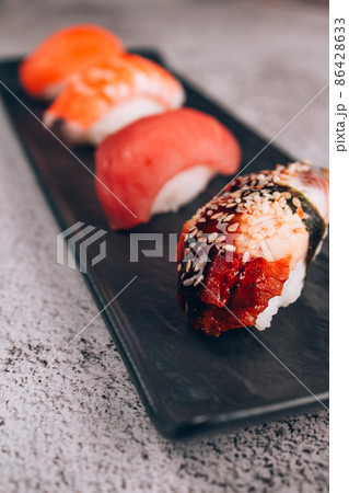 Set of traditional japanese nigiri sushi on white marble table background - with raw tuna, salmon fish, shrimp and eel. Asian food online delivery and sushi bar lunch menu concept. Vertical image Set of traditional japanese nigiri sushi on white marble table background - with raw tuna, salmon fish, shrimp and eel. Asian food online delivery and sushi bar lunch menu concept. Vertical image 86428633