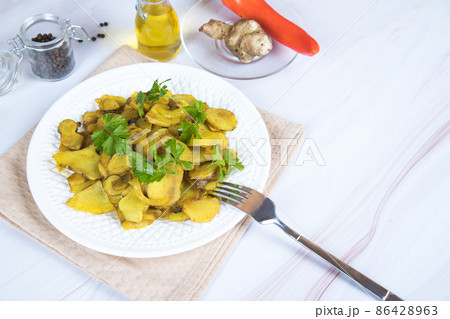 A plate of roasted jerusalem artichoke on the table with a napkin. A plate of roasted jerusalem artichoke on the table with a napkin. 86428963