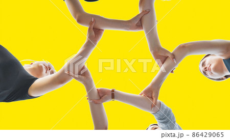 Friends join their wrist and make a circle on a yellow background. Strong friendship concept. 86429065
