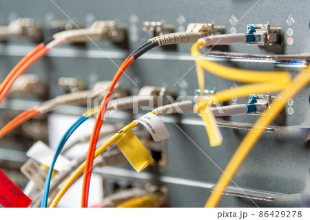 detail of server rack with fiber optic cables attached to front panel switch ports detail of server rack with fiber optic cables attached to front panel switch ports 86429278