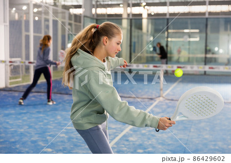 Girl tennis player playing padel tennis 86429602