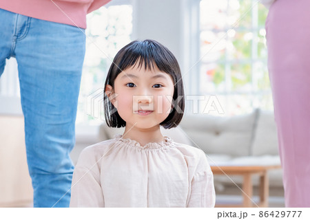 パパとママの間に座り込む笑顔の小学生 86429777