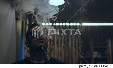 Arabic jordanian young man smokes a hookah. Arabic jordanian young man smokes a hookah. 86433581