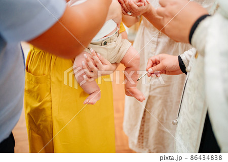 legs of the baby boy making chrismation at baptism in the church.  86434838
