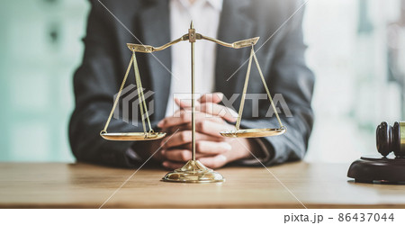 Close up golden scales with blurry lawyer as background. Close up golden scales with blurry lawyer as background. 86437044