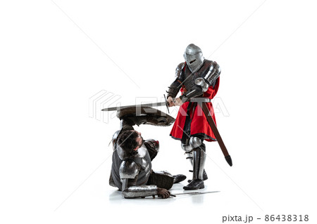 Full-length portrait of two medieval warriors, knights fighting isolated over white studio background 86438318