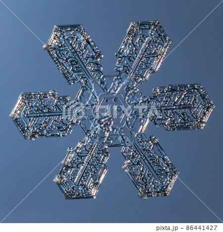 Snowflake on smooth gradient background. Macro photo of real snow crystal on glass surface. This is small snowflake with unusual pattern. Snowflake on smooth gradient background. Macro photo of real snow crystal on glass surface. This is small snowflake with unusual pattern. 86441427