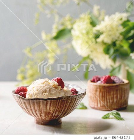 Homemade caramel vanilla ice cream with frozen raspberries Homemade caramel vanilla ice cream with frozen raspberries 86442172