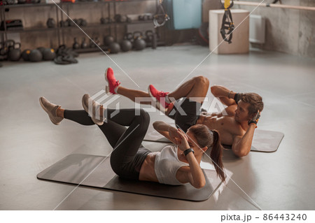 Man and woman doing exercises laying on the yoga mat Man and woman doing exercises laying on the yoga mat 86443240