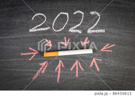 2022 commitment and change of habits. cigarette on a black chalkboard background 2022 commitment and change of habits. cigarette on a black chalkboard background 86450615